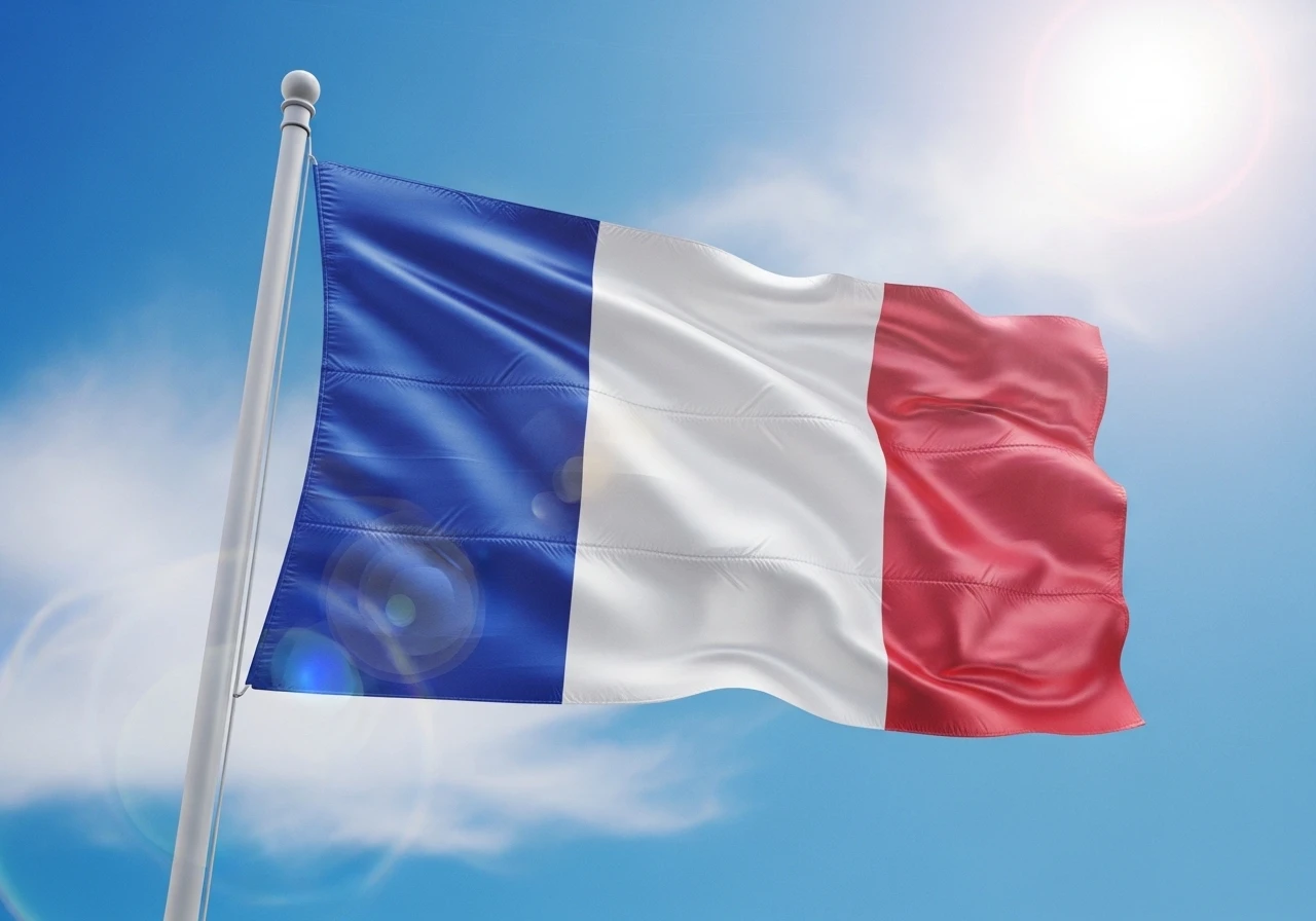 National flag of France waving against a sunny sky