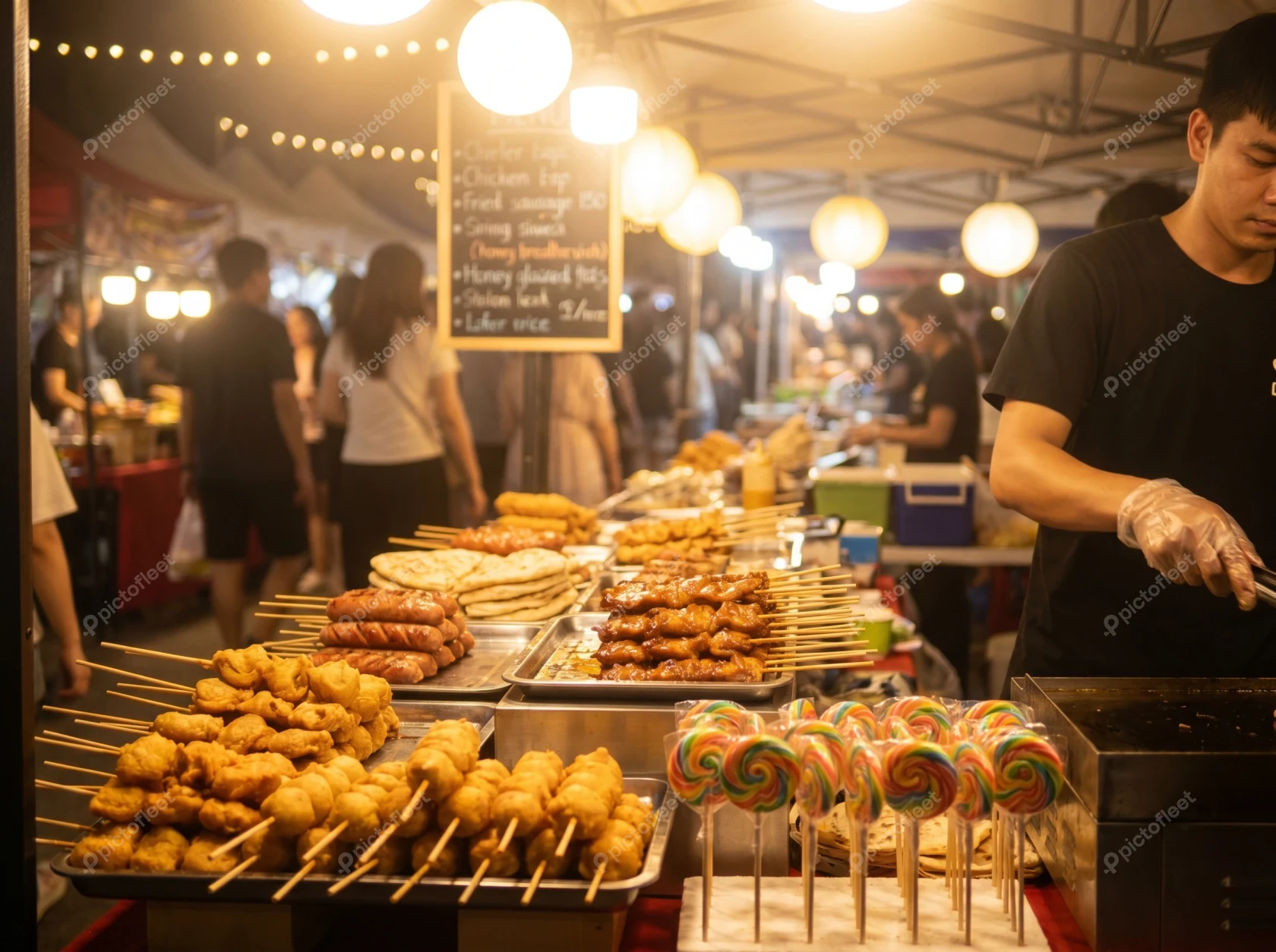 Grilled meat skewers and colorful snacks at night market stall