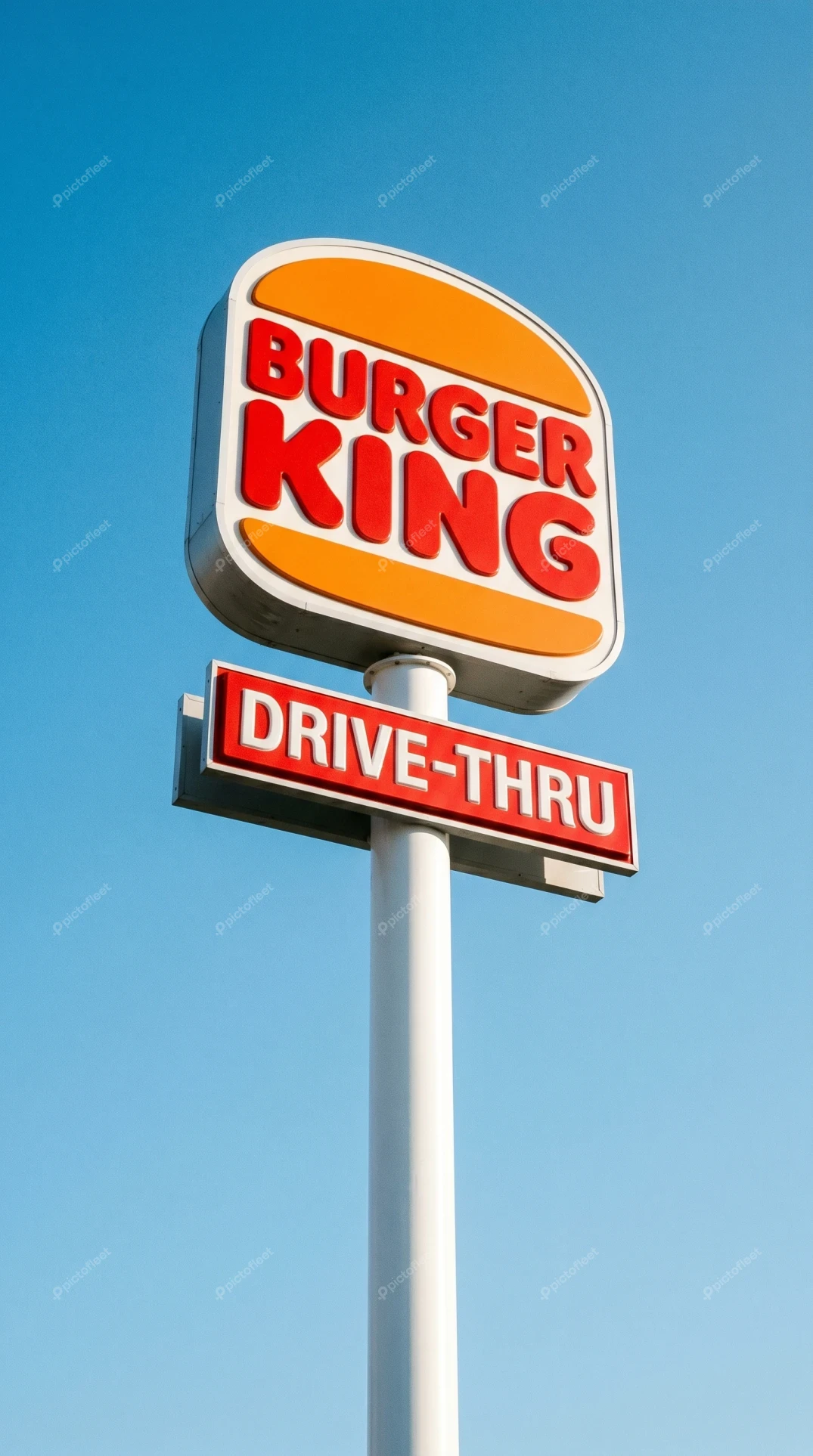 Burger King restaurant sign with drive-thru against blue sky