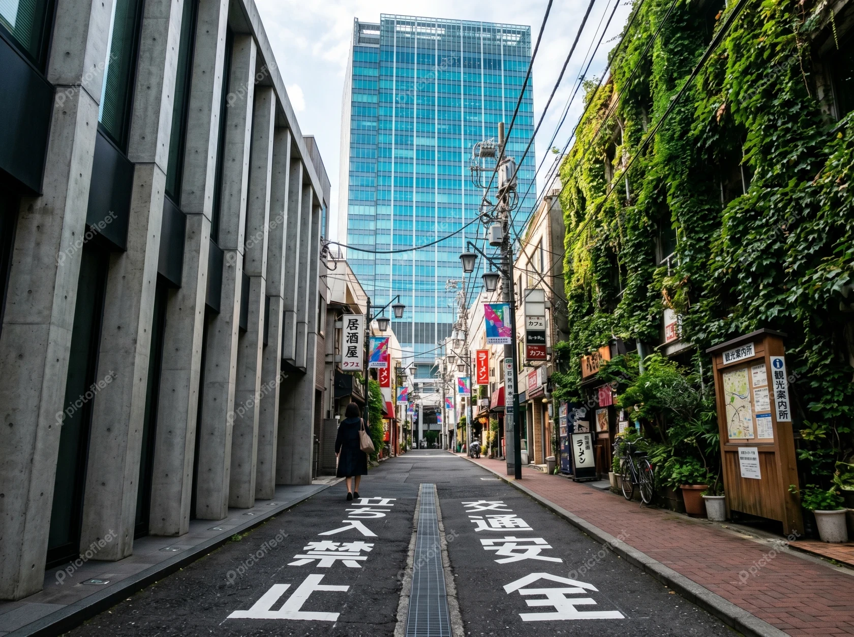 Narrow Tokyo street with ivy-covered building and modern skyscraper
