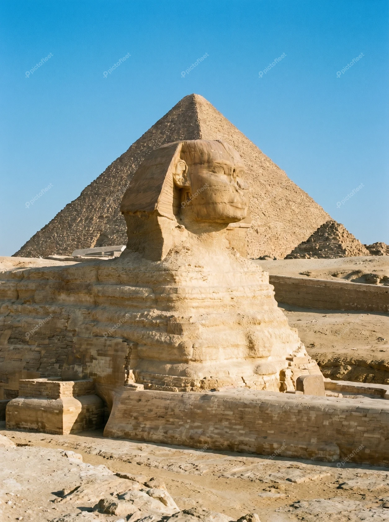 Ancient Great Sphinx of Giza with pyramid in background