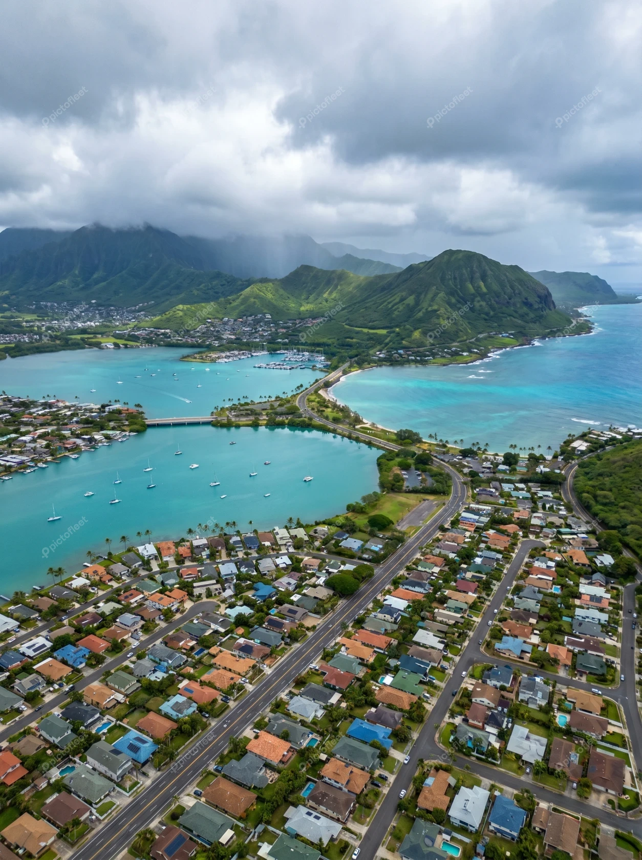 Aerial view of coastal town and lush mountains in Hawaii