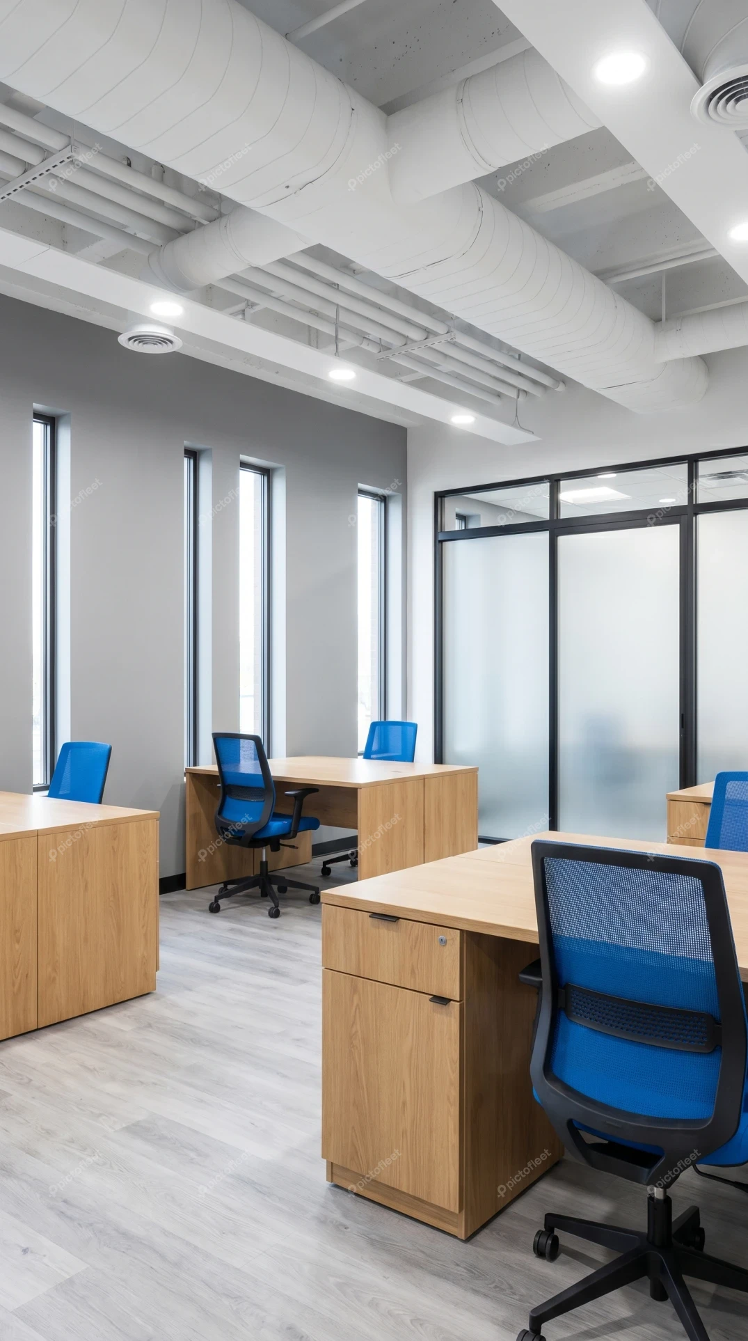 Modern office interior with wooden desks and blue chairs