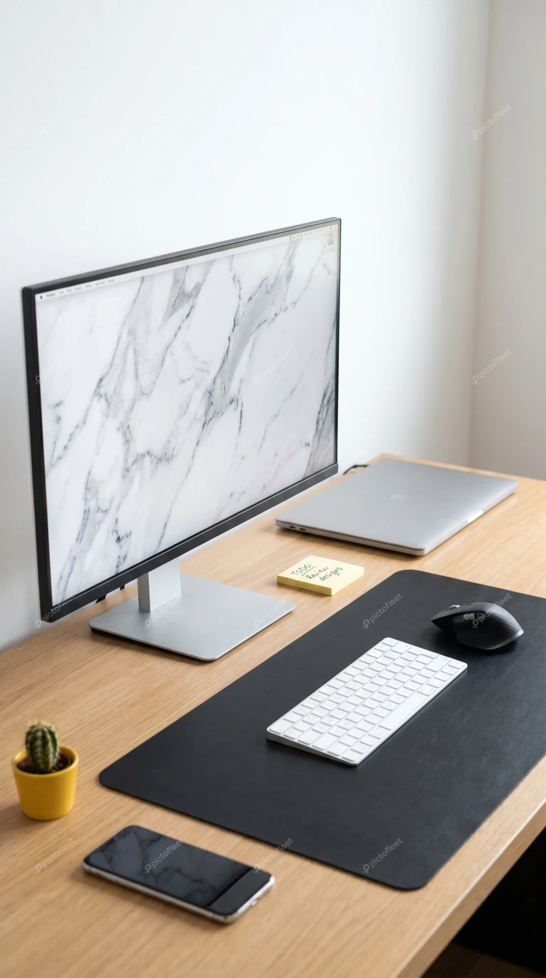 Modern minimalist workspace with computer monitor and laptop on desk