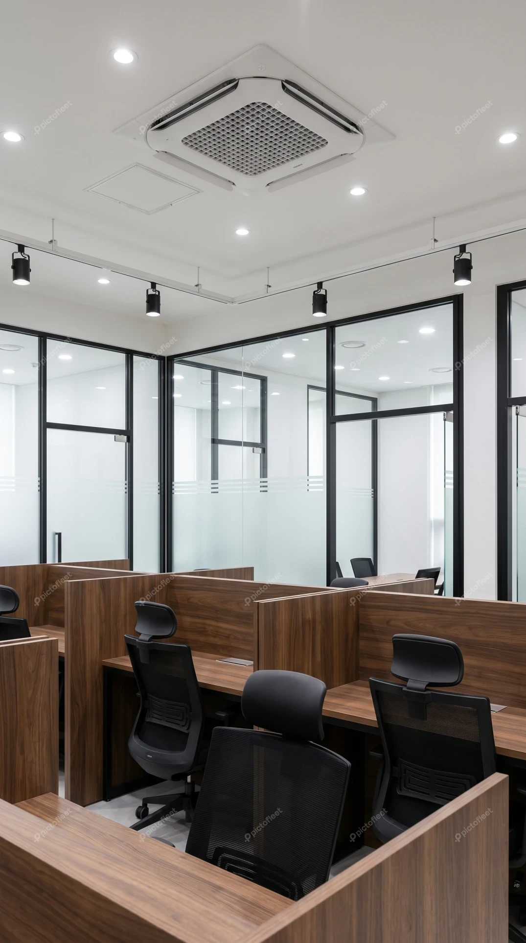 Modern office interior with wooden cubicles and glass partitions