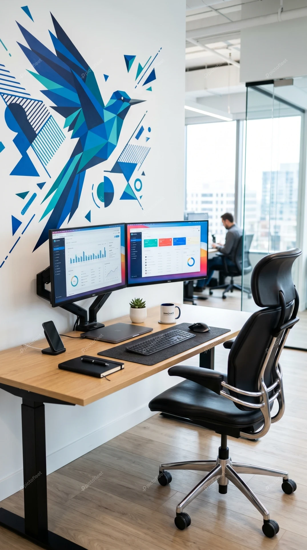 Modern ergonomic office workstation with dual monitors and mural