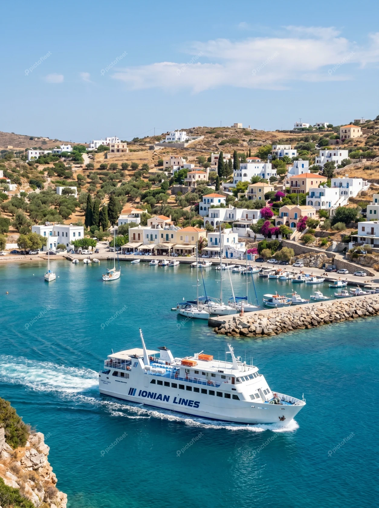 Passenger ferry cruising past a scenic Greek island village
